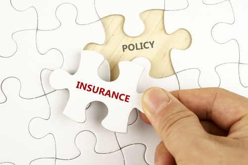 Hand fitting an insurance puzzle piece into a policy puzzle