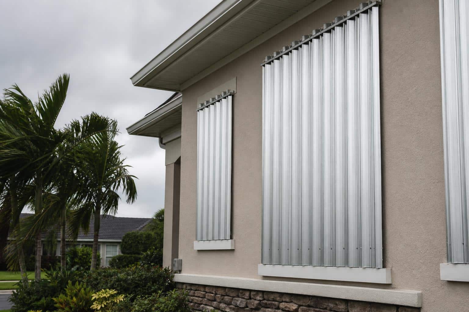 Metal hurricane shutters secured over the windows of a Florida home before a storm