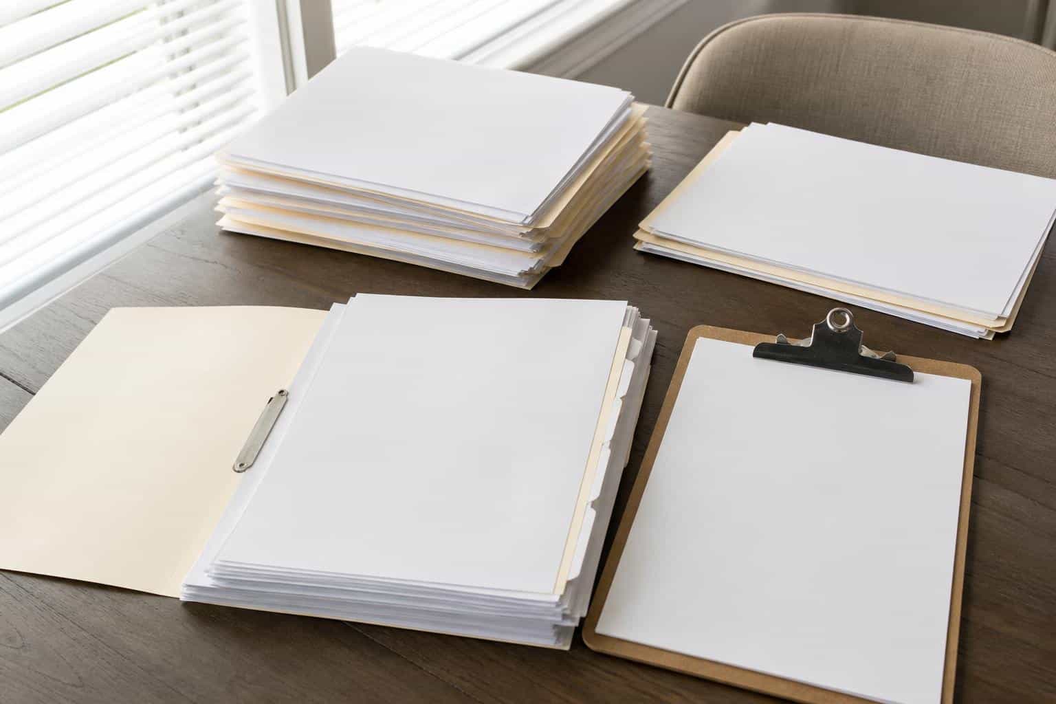 An organized folder of roof permits, inspection forms, and repair receipts with all pages blank