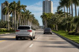 Two undamaged cars traveling on a sunny divided road in Southwest Florida
