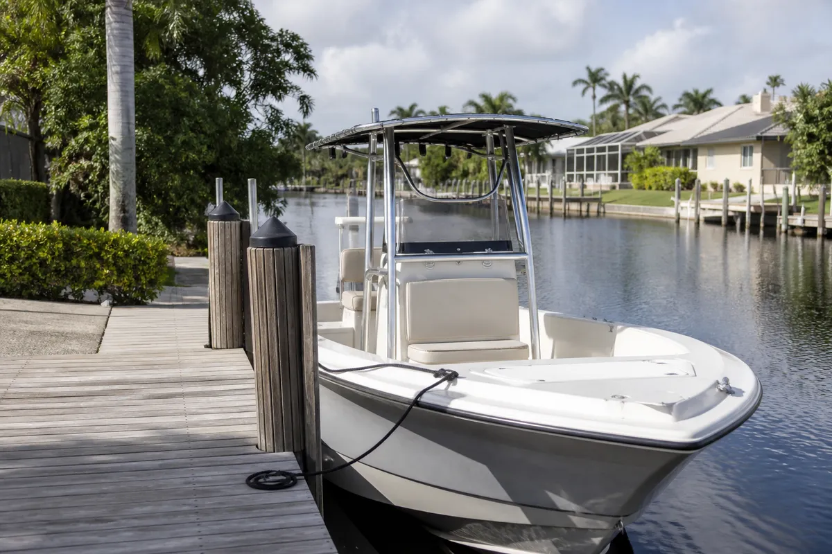Small recreational boat docked at a residential Southwest Florida canal
